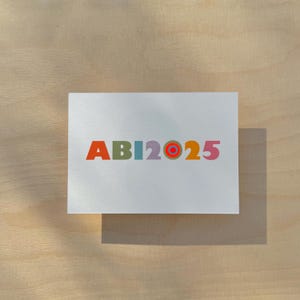Karte / Glückwunschkarte Abitur / Zielscheibe / Schriftzug „abi2025“ / Neonpunkte