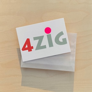 May include: A white card with the text "4ZIG" in gray letters and a pink circle above the text. The card is in a clear plastic envelope.