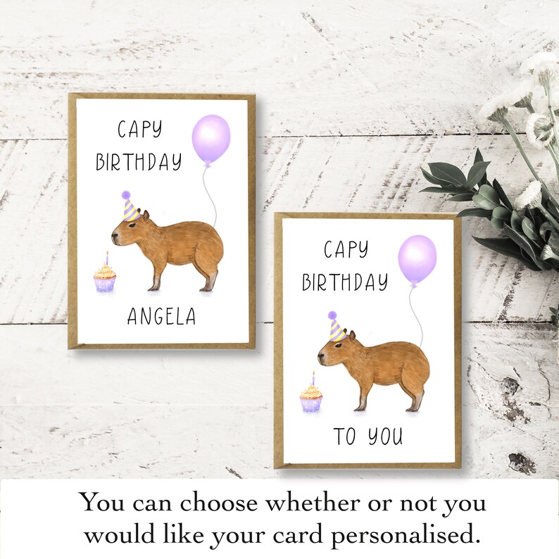 May include: Two greeting cards with a capybara wearing a party hat and holding a cupcake. The text on the cards reads "CAPY BIRTHDAY" and "TO YOU".