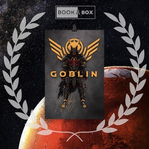 May include: A poster with a goblin warrior illustration in black and red armour, gold accents and wings. The word "GOBLIN" is in gold lettering. The poster is held by a clip against a space background, with the text "BOOK & BOX".
