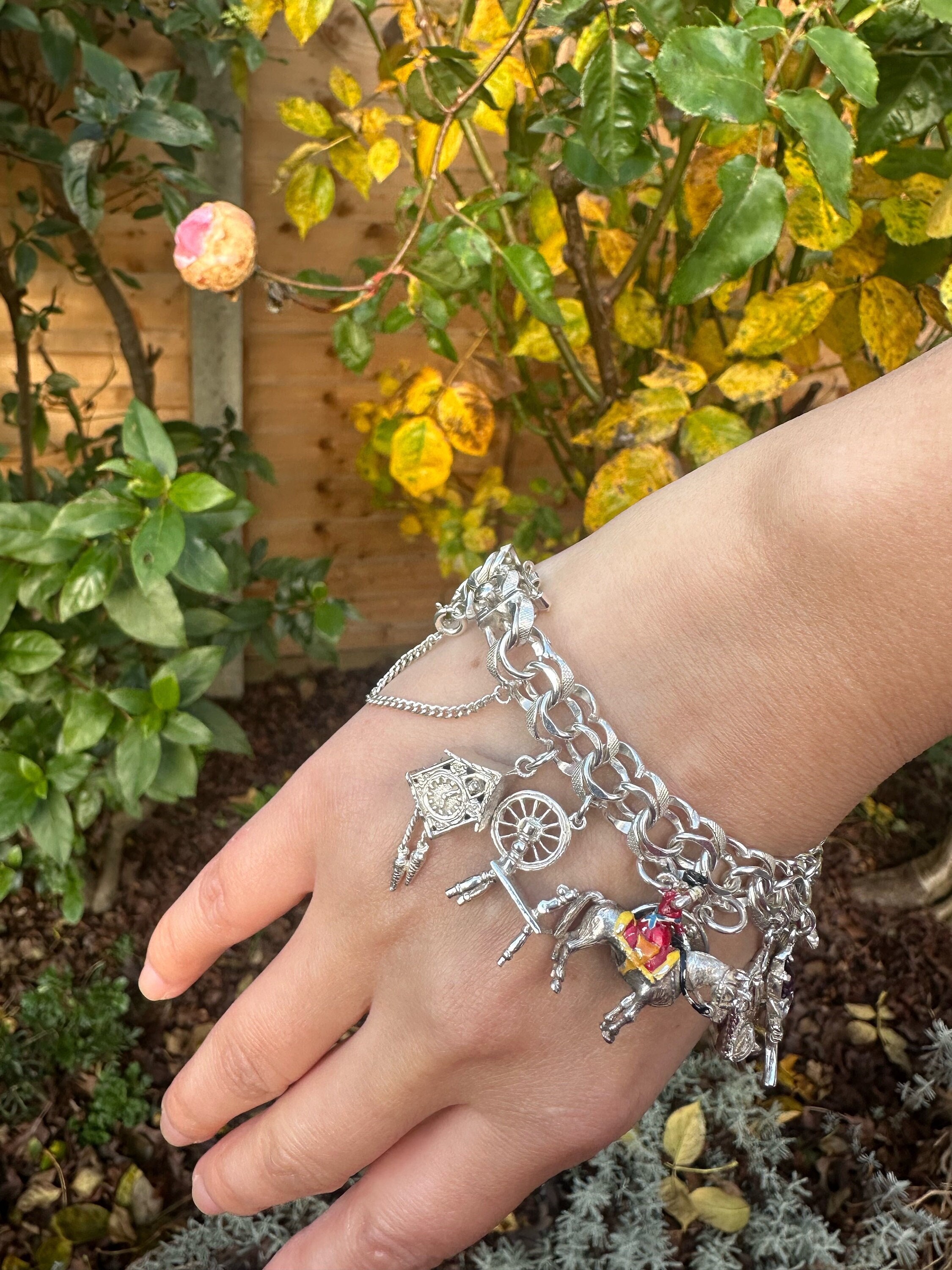 An 117g AGC Silver Charm Bracelet of 15 Charms With Intact Safety