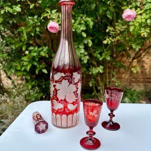 A Set of Antique Ruby Bohemian Etched Grape Vine Decanter and Two Different Sized Goblets