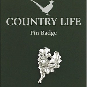Może przedstawiać: Srebrna odznaka przypinka przedstawiająca liść dębu z żołędziami. Odznaka jest wykonana ręcznie z wysokiej jakości cyny i zawiera napis "Country Life Pin Badge" nadrukowany na kartce.