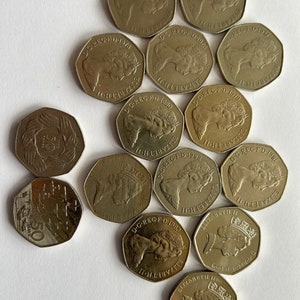 Op de afbeelding: Een verzameling van 12 zilverkleurige Britse 50 pence munten met het profiel van koningin Elizabeth II. De munten zijn gedateerd van 1978 tot 1985.