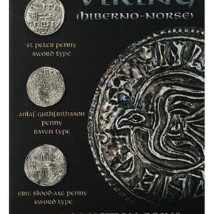 May include: Two-sided reproduction Viking coins, one side features a raven design, the other side features a sword design. The coins are labeled "St. Peter Penny Sword Type", "Anlaf Guthfrithsson Penny Raven Type", and "Eric Blood-Axe Penny Sword Type".