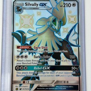 May include: Silvally GX Pokemon card, a holographic card featuring a white and blue Pokemon with black accents. The card has a HP of 210 and features the attacks Turbo Drive and Rebel GX.