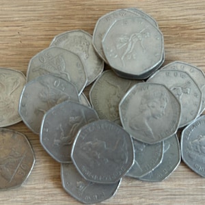 Könnte beinhalten: Eine Sammlung silberfarbener Münzen mit verschiedenen Designs, darunter ein Pferd und ein Reiter, eine Krone und ein Blumenmuster.