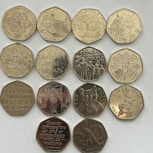 Może przedstawiać: Kolekcja 12 srebrnych brytyjskich monet 50-pencowych z różnymi wzorami, w tym kotem, królikiem, budynkiem i koroną.