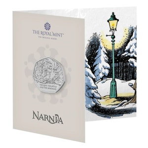 May include: A silver coin with a depiction of a snowy forest and the text "The Lion, the Witch and the Wardrobe" in a white card with the text "The Royal Mint" and "Narnia".