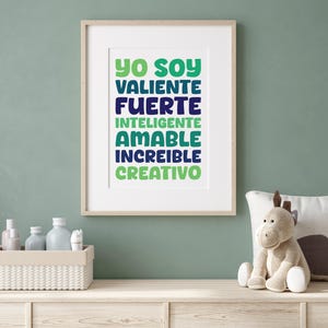 May include: A framed print with the text "Yo soy valiente fuerte inteligente amable increible creativo" in a gradient of green, blue, and navy colours.