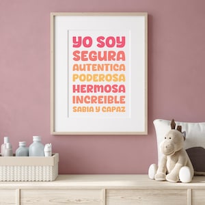 May include: A framed print with the text "Yo soy segura autentica poderosa hermosa increible sabia y capaz" in a gradient of pink, orange, and yellow.