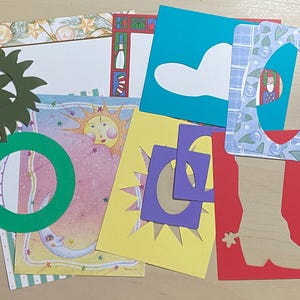 May include: A collection of assorted paper craft frames and decorative cardstock sheets featuring various die-cut shapes including a green sunburst, a green circle, a red cowboy boot, and rectangular frames in blue, yellow, and purple patterns.