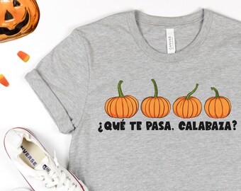 Puede incluir: Una camiseta gris con un gráfico de cuatro calabazas naranjas y el texto "¿Qué te pasa, calabaza?" en negro.