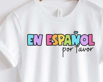 Peut inclure: T-shirt blanc avec le texte "EN ESPAÑOL por favor" en couleurs arc-en-ciel.