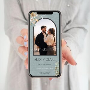 Puede incluir: Una tarjeta de guardar la fecha azul y blanca con una foto de una pareja en una puerta. El texto dice "Save the Date", "Alex & Clare", "Are Getting Married", "February 24th 2024", "At 123 Anywhere St.", "Any City, ST 12345".