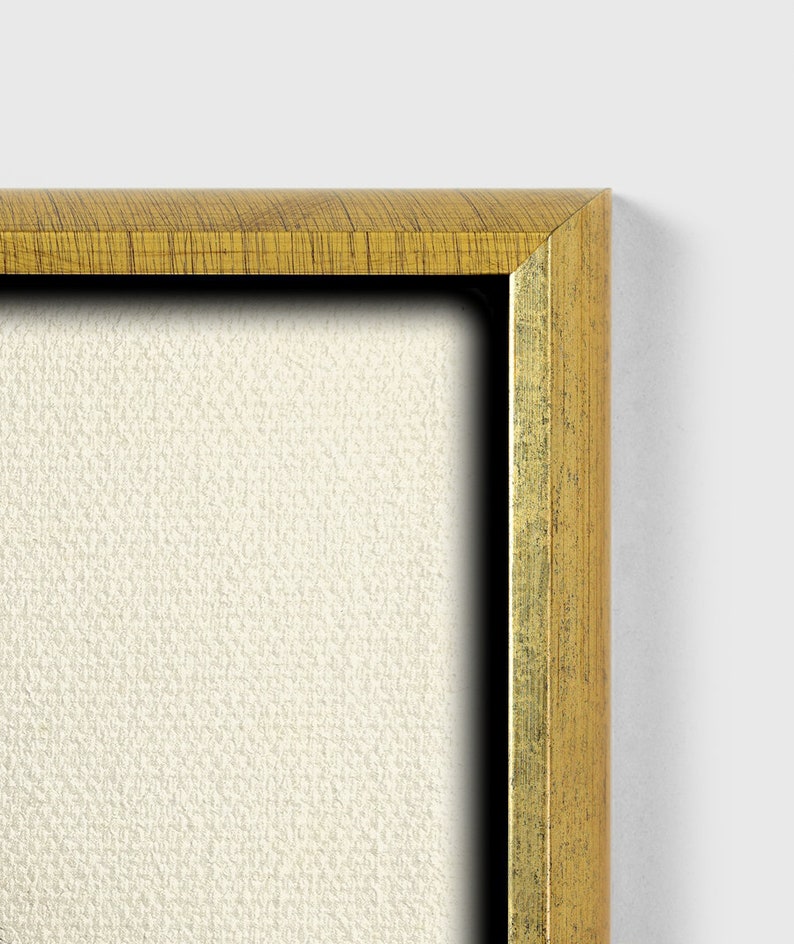 May include: Close-up of the top right corner of a gold-colored picture frame. The frame has a wood grain texture and a slightly raised edge.