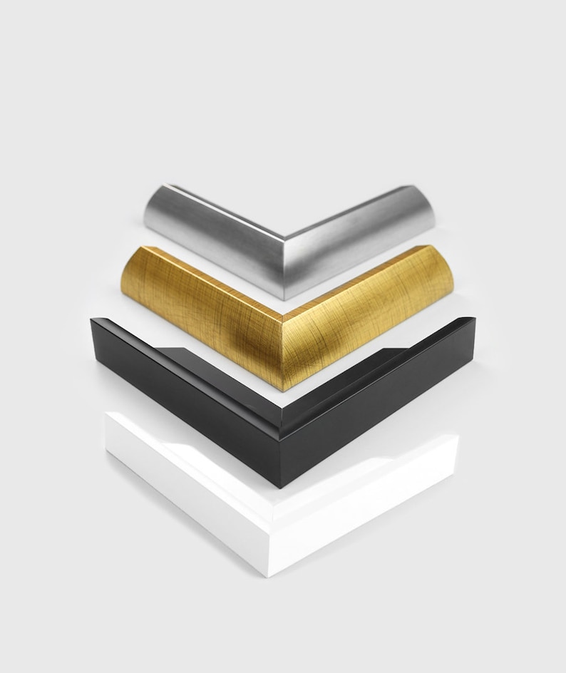 May include: Four picture frame corners in different colors: white, black, gold, and silver. The corners are stacked on top of each other.