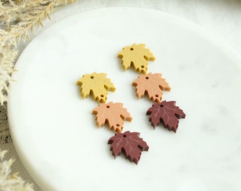 May include: Five maple leaf shaped charms in various shades of fall colors. The charms are made of resin and have two holes for attaching to jewelry or other crafts.
