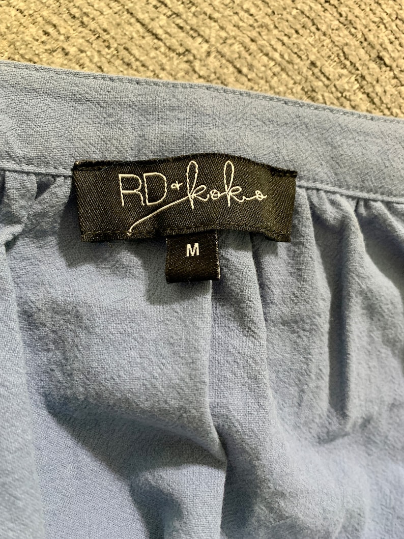 May include: A blue cotton garment with a black tag that reads "RD+koko" and a size label that says "M".