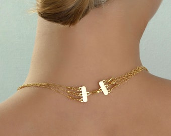May include: A gold necklace with three chains and a clasp in the back.