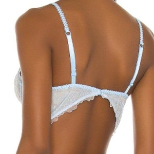 May include: A light blue lace bra with adjustable straps. The bra has a delicate floral pattern and a scalloped edge.