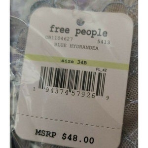 May include: A white tag with black text that reads "free people" and "OB1104627 5413 BLUE HYDRANDEA size 34B FL 42 1 94374 57926 9 MSRP $48.00".