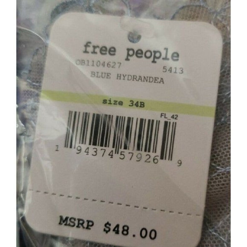 May include: A white tag with black text that reads "free people" and "OB1104627 5413 BLUE HYDRANDEA size 34B FL 42 1 94374 57926 9 MSRP $48.00".
