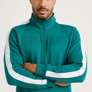 May include: Teal track jacket with white stripes down the sleeves and a high collar. The jacket has a full-length zipper and two square patch pockets on the chest. The jacket is a solid teal color.
