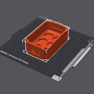 May include: A 3D printed red plastic mold for making six small objects. The mold is on a textured black surface.