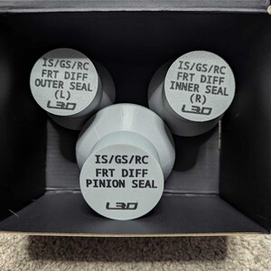 May include: Three gray plastic containers with black text labels. The labels read "IS/GS/RC FRT DIFF OUTER SEAL (L) L30", "IS/GS/RC FRT DIFF INNER SEAL (R) L30", and "IS/GS/RC FRT DIFF PINION SEAL L30".