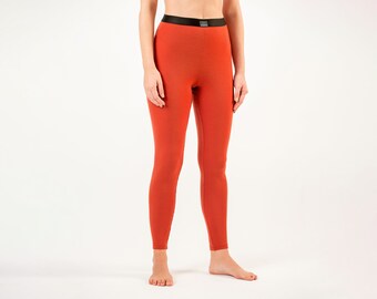 Op de afbeelding: Een paar roestkleurige thermische leggings met een zwarte tailleband.