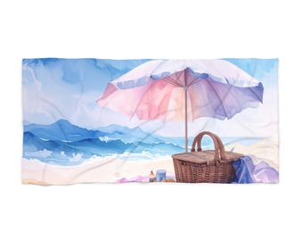 May include: Beach towel with a watercolour illustration of a beach scene. A pink and white striped parasol shades a picnic basket and a blue towel. The background depicts the ocean and sky.