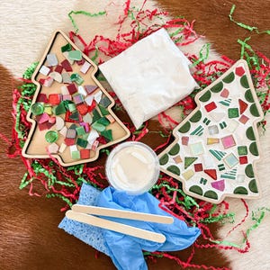 May include: A Christmas tree mosaic kit with two wooden tree-shaped bases, colorful mosaic tiles, grout, a sponge, wooden sticks, and blue gloves. The kit includes red and green paper shreds.