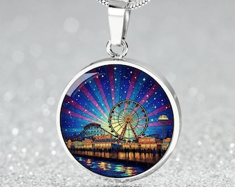 May include: A silver pendant necklace with a round charm featuring a colorful illustration of a Ferris wheel, roller coaster, and Coney Island at night. The charm has a silver border and hangs from a silver chain.