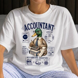 Può includere: Una t-shirt bianca con la grafica di un germano reale che indossa occhiali e cravatta, al lavoro su una scrivania con una calcolatrice e un libro etichettato SPREADSHEETS OF DOOM. Il design include testi come ACCOUNTANT, DIET e ACCOUNTING EQUATION.