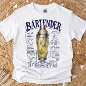 Könnte beinhalten: Ein weißes T-Shirt mit einer zentralen Grafik eines Cocktail-Shakers, gefüllt mit Eis und Limettenscheiben. Das Design enthält den Text "BARTENDER" und verschiedene Diagramme mit den Bezeichnungen "BARTENDER'S PYRAMID OF NEEDS", "EQUATION OF A GOOD DRINK" und "BARTENDER WEATHER FORECAST" sowie den Satz "SAVING PEOPLE FROM SOBRIETY ONE DRINK AT A TIME."