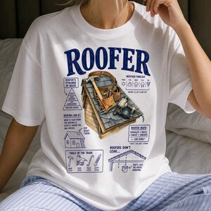 Può includere: Una t-shirt bianca con una grafica blu intitolata ROOFER. Il design include una sezione di tetto con cintura porta attrezzi, martello e sparachiodi, circondato da riquadri di testo come Roofer's Pyramid of Needs, Roofing Law #1, Weather Forecast, Roofer Math, Tools of the Trade e Roofers Don't Leak.