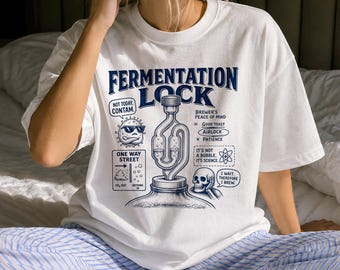 May include: A white t-shirt featuring a dark blue graphic print of a fermentation airlock. The design includes text reading FERMENTATION LOCK, NOT TODAY CONTAM, ONE WAY STREET, BREWER'S PEACE OF MIND, and I WAIT THEREFORE I BREW with illustrations.
