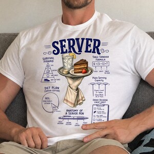 May include: A white t-shirt featuring a blue graphic titled SERVER. The design includes a hand holding a tray with a drink and cake, surrounded by diagrams labeled Survival Pyramid, Table Turnover Formula, Diet Plan, Plate Spinning Capacity, and Anatomy of a Server Pen with detailed text and illustrations.