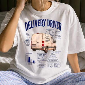 Op de afbeelding: Een wit t-shirt met een blauwe grafische print met de titel DELIVERY DRIVER. Het ontwerp bevat een beige bestelwagen, een koffiemok, een cirkeldiagram, een staafdiagram, een piramidediagram en diverse teksten over werkzaamheden en formules.