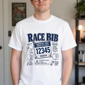 Puede incluir: Una camiseta blanca con un estampado gráfico azul oscuro con el texto RACE BIB, un número de carrera 12345, un gráfico circular etiquetado como 90% hope, una cara de meme con el texto Y U NO STAY ON MY SHIRT y una lista de efectos secundarios.