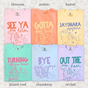 May include: Six colorful t-shirts with fun graphics and text. The shirts are in shades of pink, orange, yellow, green, blue, and purple. Each shirt features a different animal wearing sunglasses and a backpack, with phrases like "See Ya Later" and "Sayonara Capybara."
