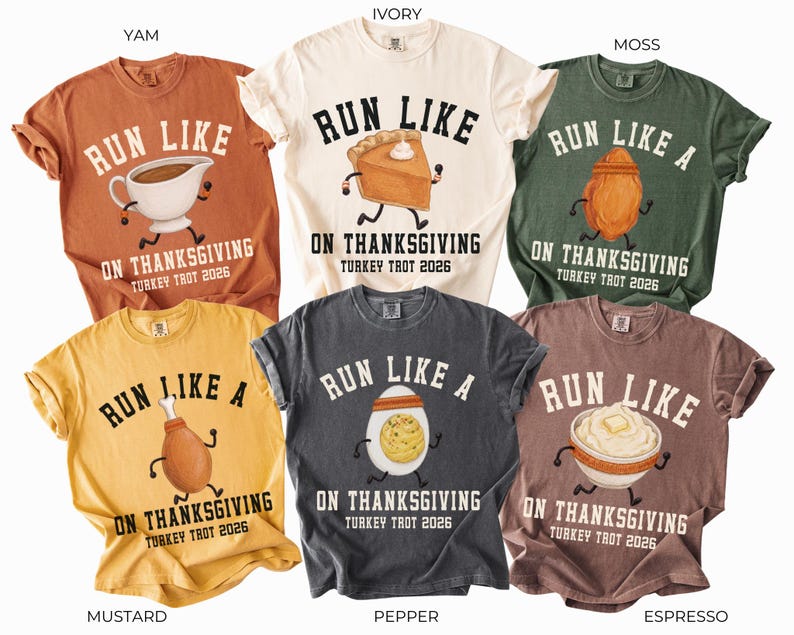 May include: Six short-sleeve crew neck t-shirts in yam, ivory, moss, mustard, pepper, and espresso colors. Each shirt features a graphic of a Thanksgiving food item with arms and legs running, and the text RUN LIKE A ON THANKSGIVING TURKEY TROT 2026.