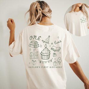 Peut inclure: Une tasse en céramique blanche avec une anse noire et le texte "But First, Coffee" en gras noir. La tasse est posée sur un fond flou, suggérant un cadre chaleureux.