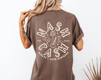 May include: Brown t-shirt with a cream-colored graphic on the back. The graphic says "NASH BASH" with a cowboy hat, guitar, and boots. The text "ASHLEY'S 30TH BIRTHDAY" is also included.