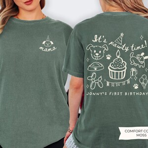 May include: Moss green t-shirt with white graphic designs. The front features a dog with a party hat and the word "mama". The back displays the text "It's pawty time!" with dog-themed illustrations and "Jonny's First Birthday".