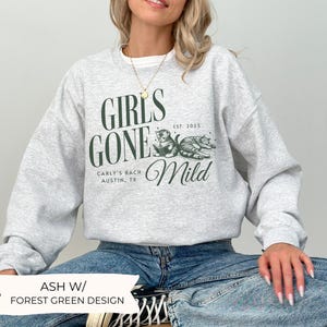 May include: A gray sweatshirt with a forest green design that says "Girls Gone Mild" with two cats and the text "Carly's Bach Austin, TX Est. 2025."