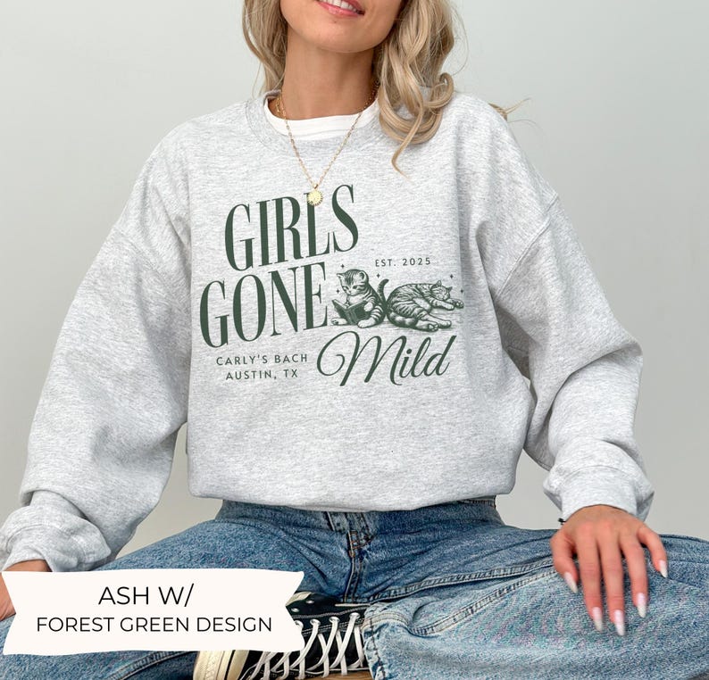 May include: A gray sweatshirt with a forest green design that says "Girls Gone Mild" with two cats and the text "Carly's Bach Austin, TX Est. 2025."