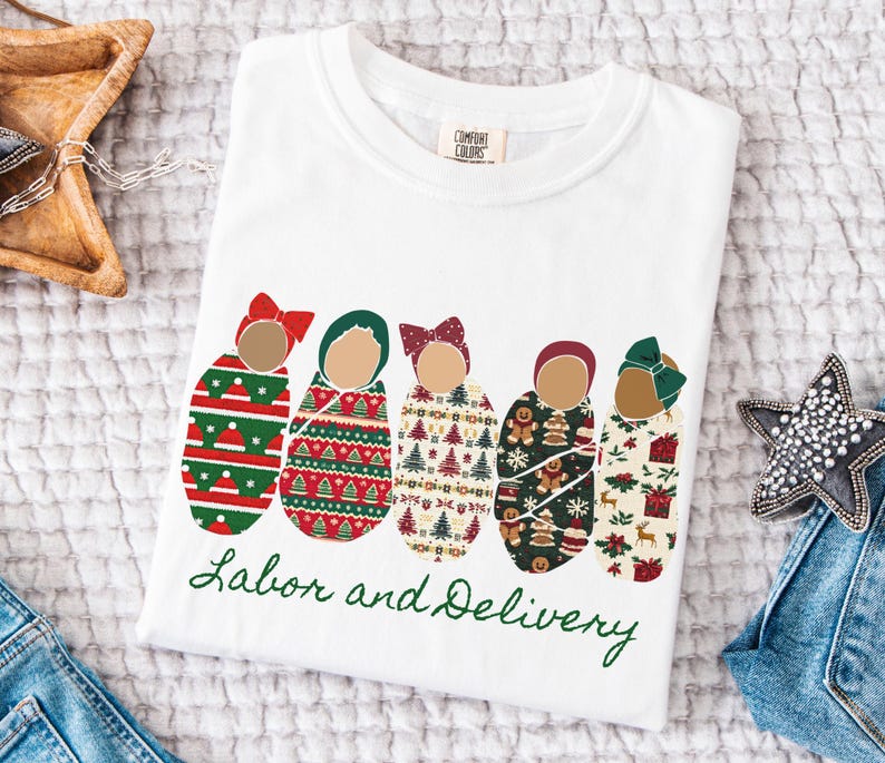 Peut inclure: T-shirt blanc avec un motif festif repr&eacute;sentant cinq b&eacute;b&eacute;s emmaillot&eacute;s, chacun orn&eacute; d'un n&oelig;ud et envelopp&eacute; dans des motifs sur le th&egrave;me des f&ecirc;tes. Les mots "Labor and Delivery" sont &eacute;crits en vert.