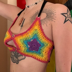 May include: A rainbow crochet top with a star design. The top has a cutout in the front and is made with a variety of colorful yarns.